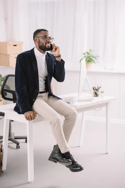 Professionele Afro Amerikaanse Zakenman Praten Smartphone Terwijl Zittend Tafel Moderne — Gratis stockfoto