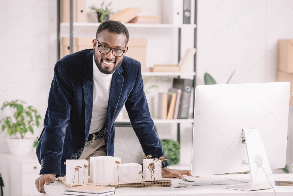 successful african american architect working with business buildings model and computer in modern office 