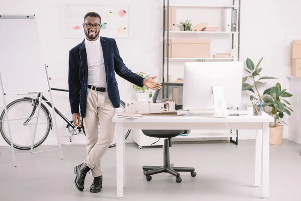 アフリカ系アメリカ人の建築家がコンピューターとオフィスでビジネスの建物モデルを操作を笑顔 — ストック写真