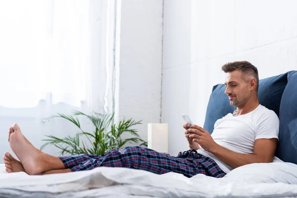 Hombre Adulto Camiseta Blanca Usando Teléfono Inteligente Durante Mañana Cama —  Fotos de Stock