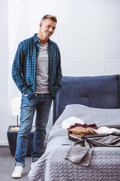 Homme Joyeux Debout Près Des Bagages Dans Chambre Coucher Maison — Photo gratuite