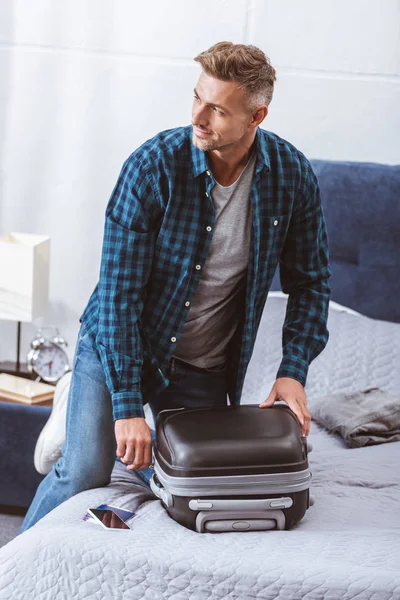 Man Packing Travel Bag Looking Away Bedroom Home — Free Stock Photo
