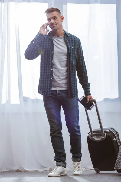 Volwassen Mannelijke Reiziger Met Paspoort Uitvoering Wielen Tas Praten Smartphone — Gratis stockfoto