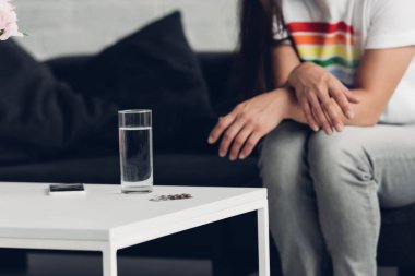 t-shirt erkekte bardak bardak su ve pill önünde oturan gurur bayrak ile kırpılmış
