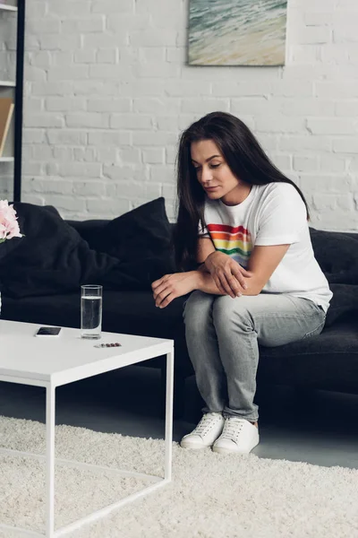 Jong Transgender Vrouw Zitten Bank Thuis Kijken Naar Pillen Water — Stockfoto