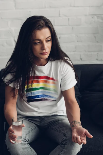 Mujer Joven Transgénero Deprimida Con Píldora Vaso Agua Sentado Sofá — Foto de Stock