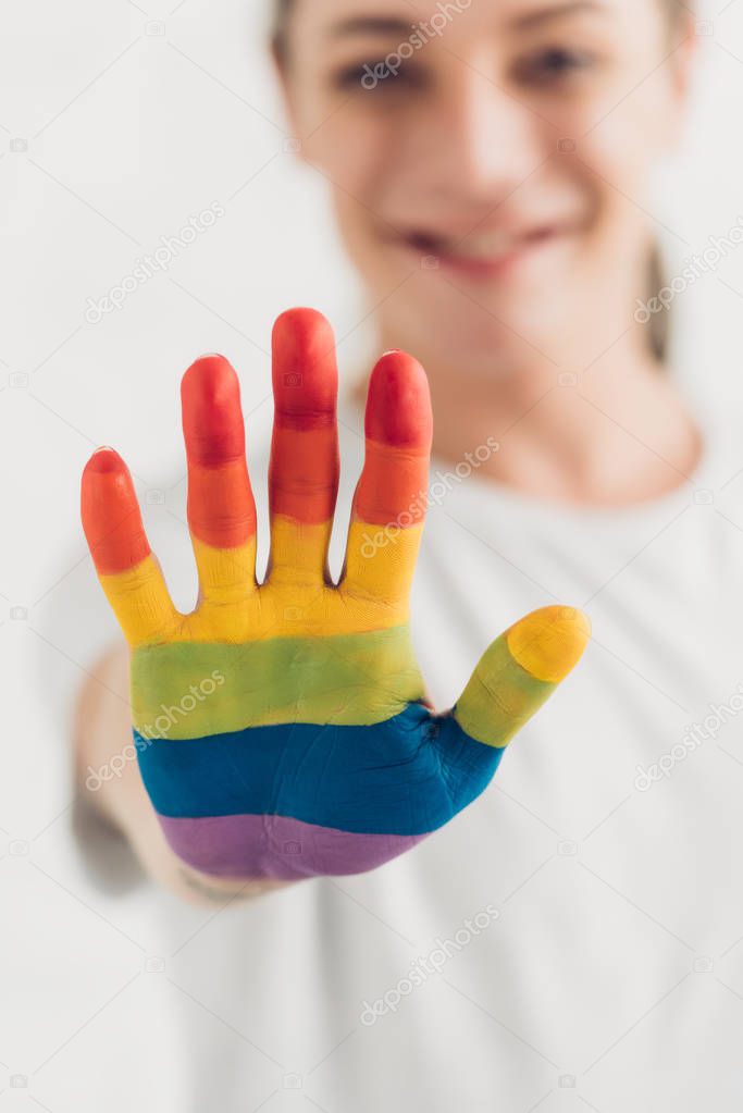 close-up shot of transgender woman showing hand painted in colors of pride flag at home