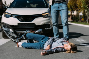 partial view of young woman mowed down by driver in car on road, car accident concept clipart