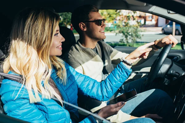 Lächelnde Frau Mit Smartphone Zeigt Freund Auto Die Richtung — Stockfoto