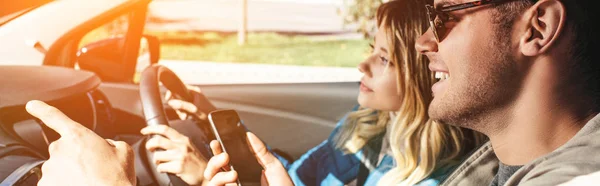 Улыбающийся Мужчина Смартфоном Показывает Направление Девушке Вождение Автомобиля — стоковое фото