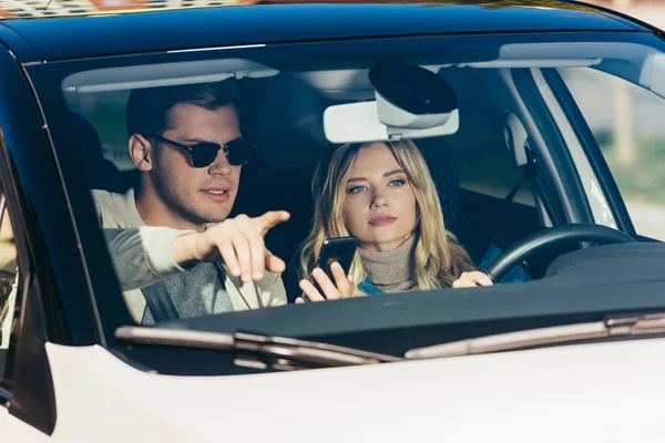 Man Met Smartphone Richting Tonen Aan Vriendin Auto — Stockfoto