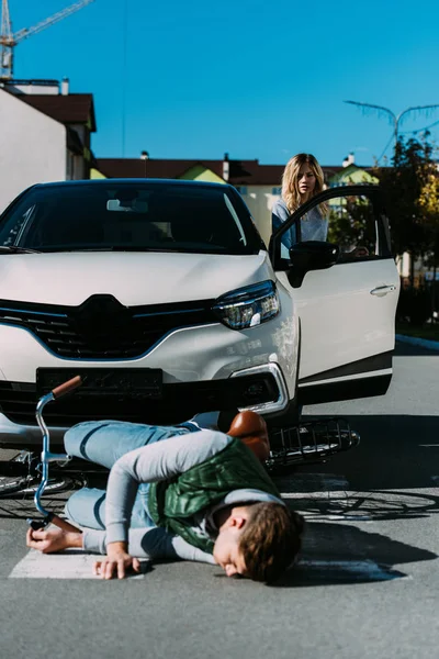 Arabanın Kapısını Açarak Motorlu Araç Çarpışmadan Sonra Yolda Yatan Yaralı — Ücretsiz Stok Fotoğraf