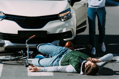 Motorlu araç çarpışma, yaralı bisikletçi için çalışan kadının kırpılmış atış