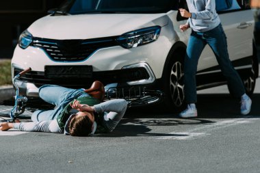 cropped shot of woman running to injured cyclist at traffic accident  clipart