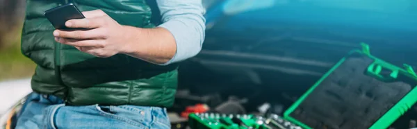 Cropped Shot Young Man Sitting Broken Car Using Smartphone — Free Stock Photo