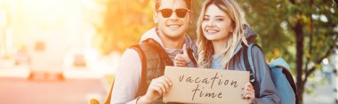 mutlu genç çift kart Yazıtı tatil zamanı ile tutarak yolcuları 
