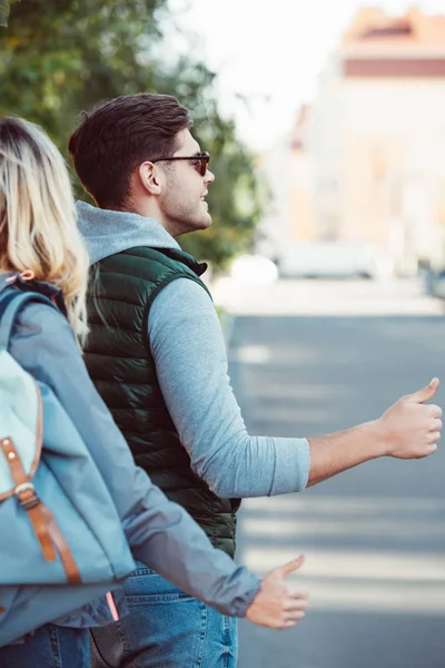 Cropped Shot Young Couple Hitchhiking Road — Free Stock Photo