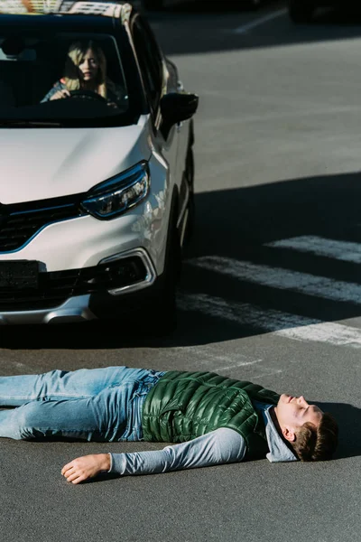 交通碰撞后受伤青年躺在路上的高视角 — 免费的图库照片