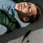 Close-up view of injured young man on road after traffic accident
