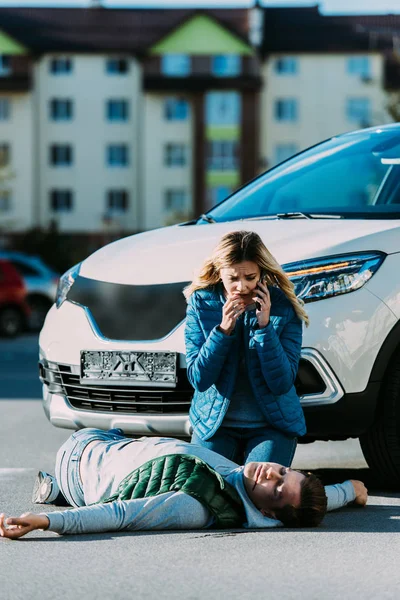 Mujer Joven Asustada Llamando Emergencia Mirando Hombre Herido Tirado Carretera — Foto de Stock