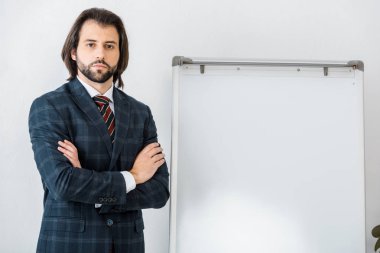 Genç ciddi erkek Sigorta acentası ile silah ayakta beyaz tahta Office yakınındaki geçti