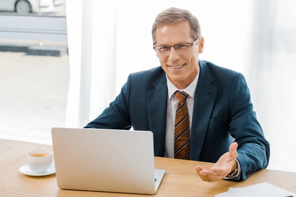 Adulto Sonriente Hombre Gafas Sentado Mesa Con Ordenador Portátil Oficina —  Fotos de Stock