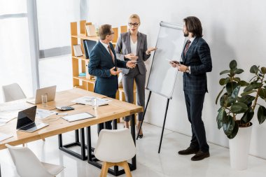 beyaz tahta duran ve tartışma sahip ofis çalışanları 