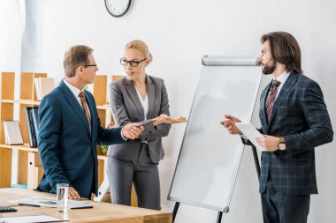 beyaz tahta duran ve tartışma sahip ofis çalışanları 