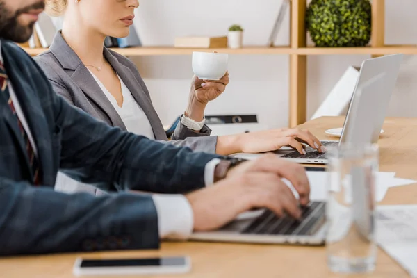 Hombre Usando Ordenador Portátil Mujer Sosteniendo Taza Mesa Oficina —  Fotos de Stock