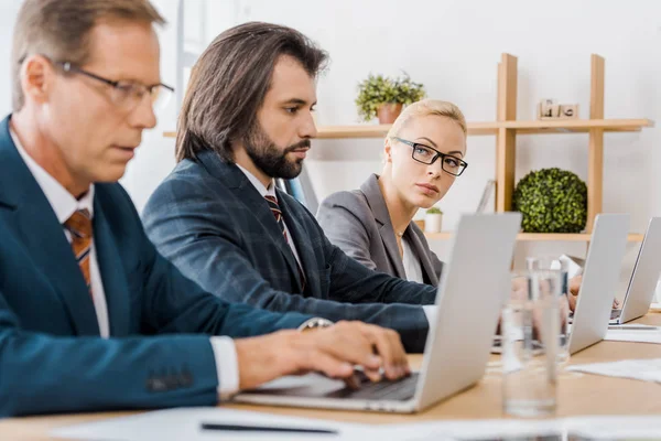 Trabajadores Seguros Sentados Mesa Usando Computadoras Portátiles Oficina — Foto de stock gratis