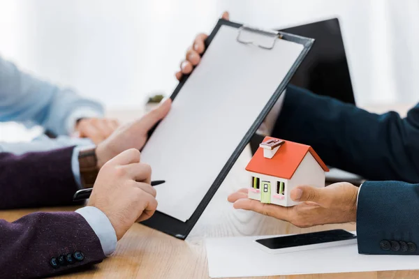 Man Signing Contract Clipboard While Insurance Agent Holding House Model — Stock Photo, Image