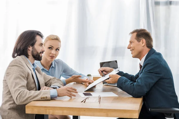 Businessman Showing Contract Clipboard Couple Signing — Stock Photo, Image