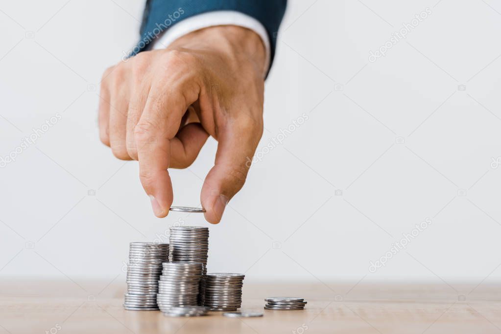 male hand picking silver coin from wooden table