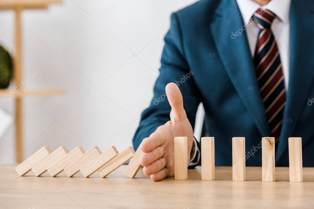 close up of businessman with blocks wood game in office, insurance concept
