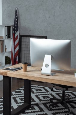 Tek kullanımlık kahve Kupası ve bilgisayar monitörü modern Office ile çalışma alanı'nın seçici odak 