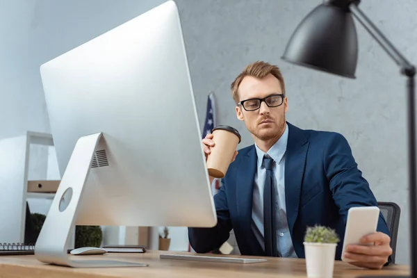 Hombre Negocios Guapo Sosteniendo Taza Papel Café Uso Teléfono Inteligente — Foto de stock gratuita