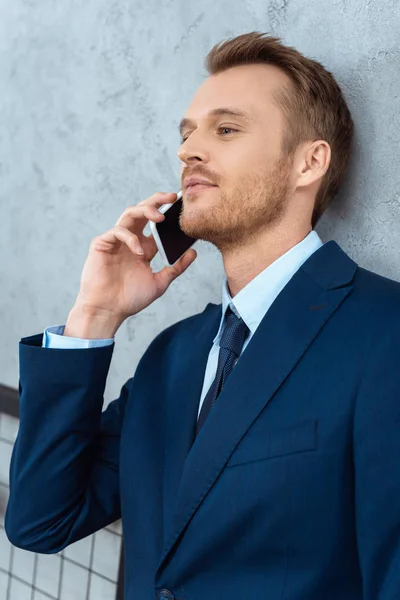 Young Smiling Businessman Suit Talking Smartphone Modern Office — Free Stock Photo