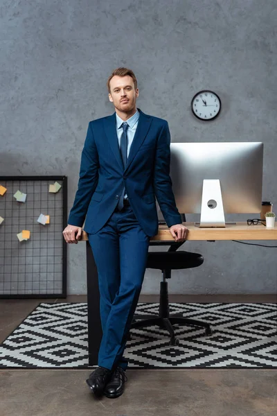 Joyful Young Businessman Suit Standing Table Computer Monitor Office — Stock Photo, Image