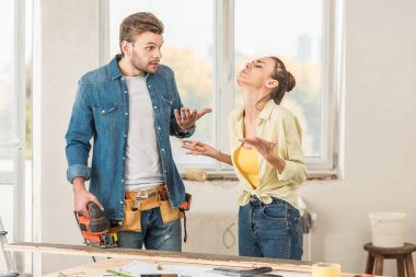 emotional young couple quarreling during home improvement clipart