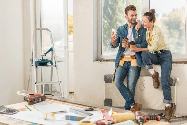 Feliz Pareja Joven Sosteniendo Vasos Papel Utilizando Reparación Teléfonos Inteligentes — Foto de Stock