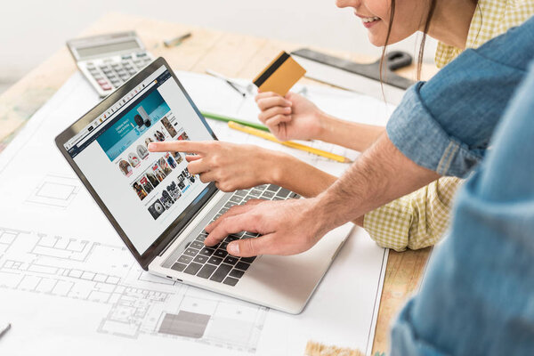 cropped shot of young couple with credit card using laptop with amazon website