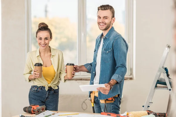 Feliz Jovem Casal Segurando Copos Papel Tablet Digital Durante Renovação — Fotografia de Stock