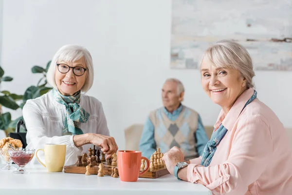 Senior Vrouwen Spelen Schaak Drinken Koffie Terwijl Senior Man Zit — Stockfoto