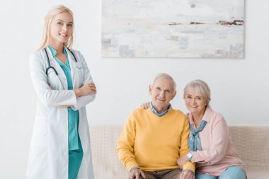 kadın doktor klinik kıdemli gülümseyen hastalarda yakın duran