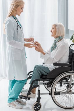 Genç kadın doktor ilaç veren kadın kıdemli devre dışı 