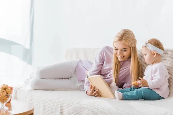 Young Smiling Mother Reading Book Small Daughter While Toddler Holding — Stock Photo, Image