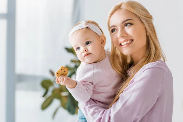 Jovem Mãe Segurando Pequena Filha Bonito Com Biscoito — Fotografia de Stock