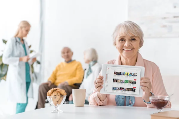 Senior Woman Showing Youtube Channel Digital Tablet Screen Nursing Home — Stock Photo, Image