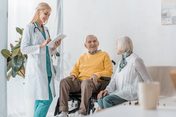 young smiling female doctor examining senior people at nursing home