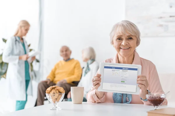 Senior Woman Showing Facebook App Digital Tablet Screen Nursing Home — Stock Photo, Image